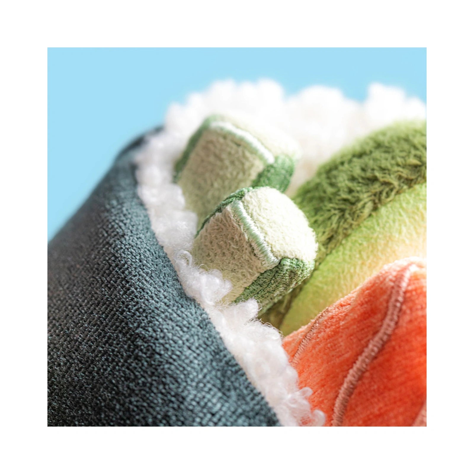 A close up detail of the Jellycat Amuseables Coneroi Temaki plush toy showing the textured dark green nori wrap, curly white rice, and colorful plush fillings including orange salmon, green avocado and cucumber.