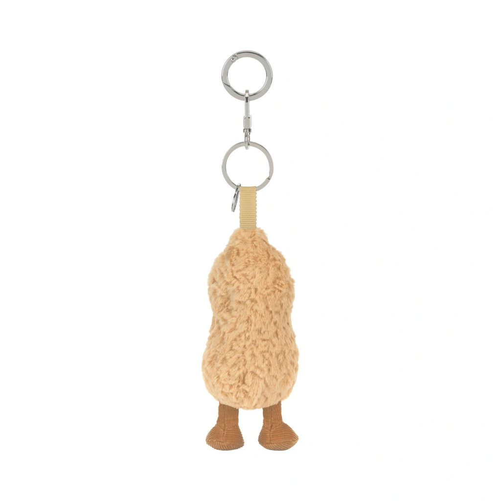 A plush peanut-shaped keychain charm in a textured tan fleece, featuring small brown feet and a silver metal key ring at the top, shown against a plain white background.