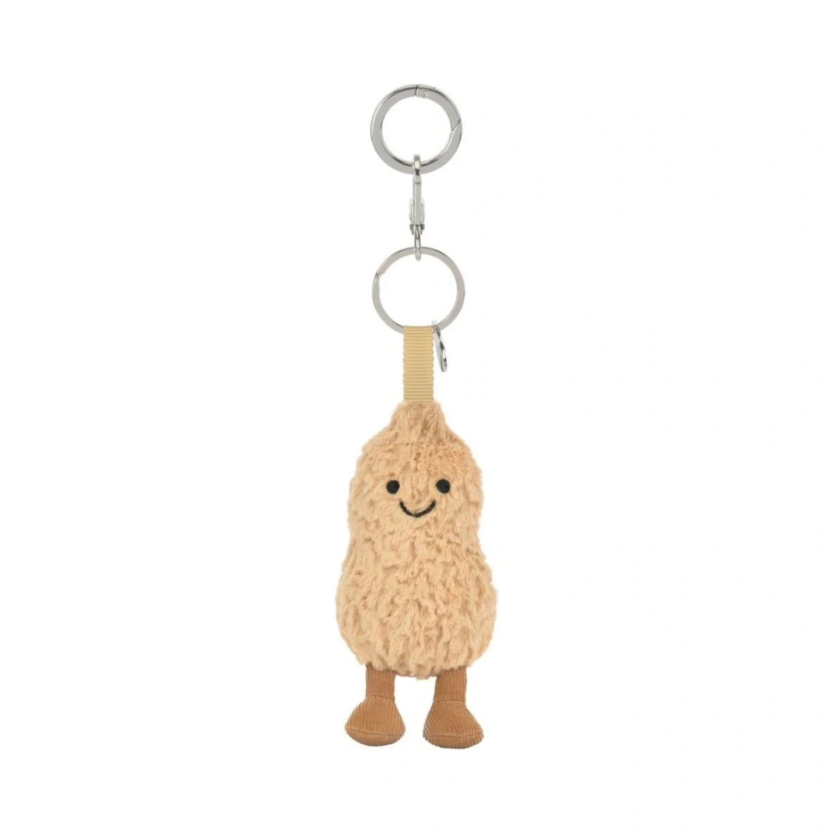 A plush peanut-shaped keychain charm with a smiling embroidered face, attached to silver metal key rings and a beige fabric loop, shown on a plain white background.
