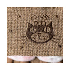 Close up detail of Jellycat Amuseables Smores showing brown waffle knit plush and an intricate embroidered cat face.