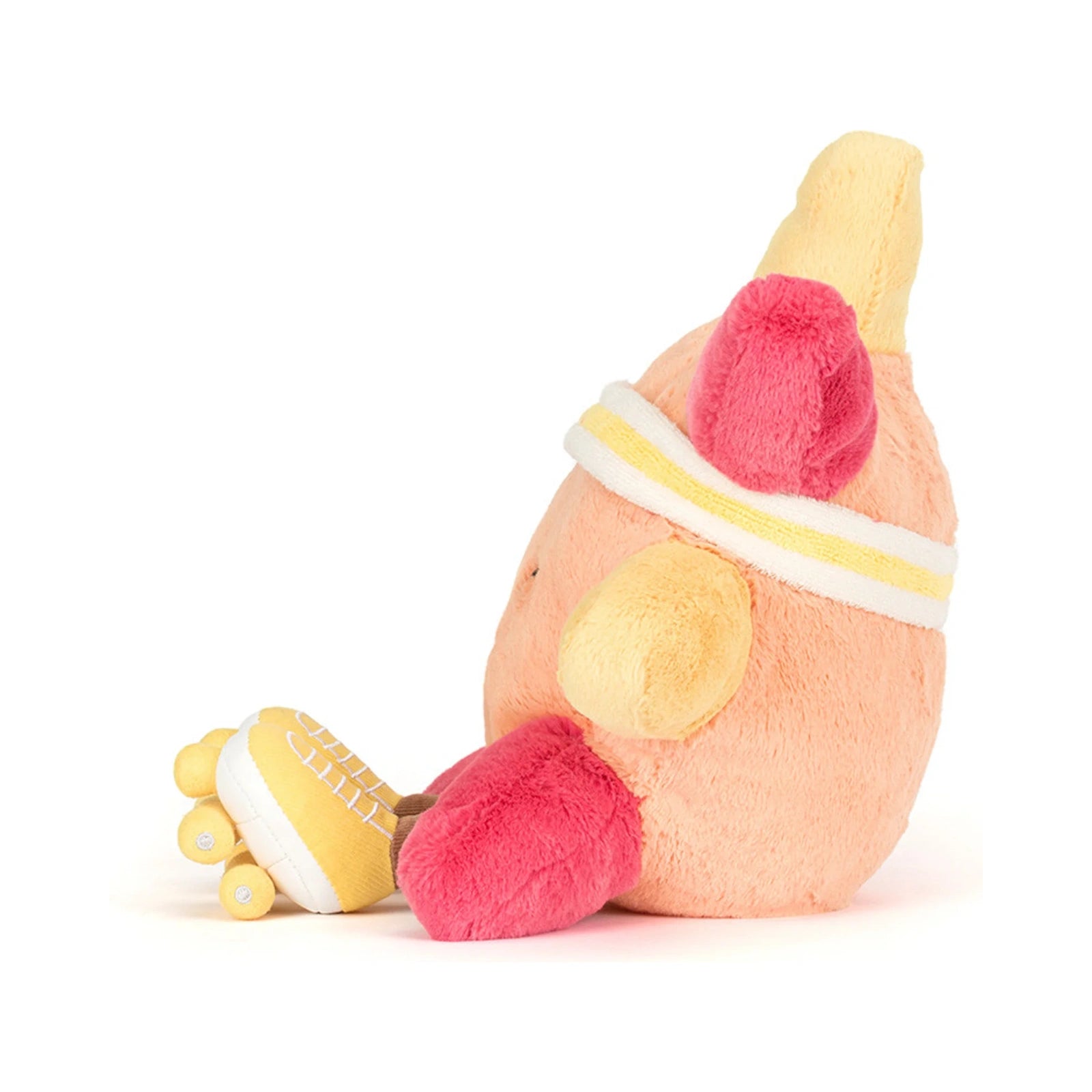 A Jellycat Amuseables Sun Roller Skates plush toy in a soft peach orange color shown from a side profile, wearing a yellow and white striped athletic headband and yellow roller skates with tiny wheels.