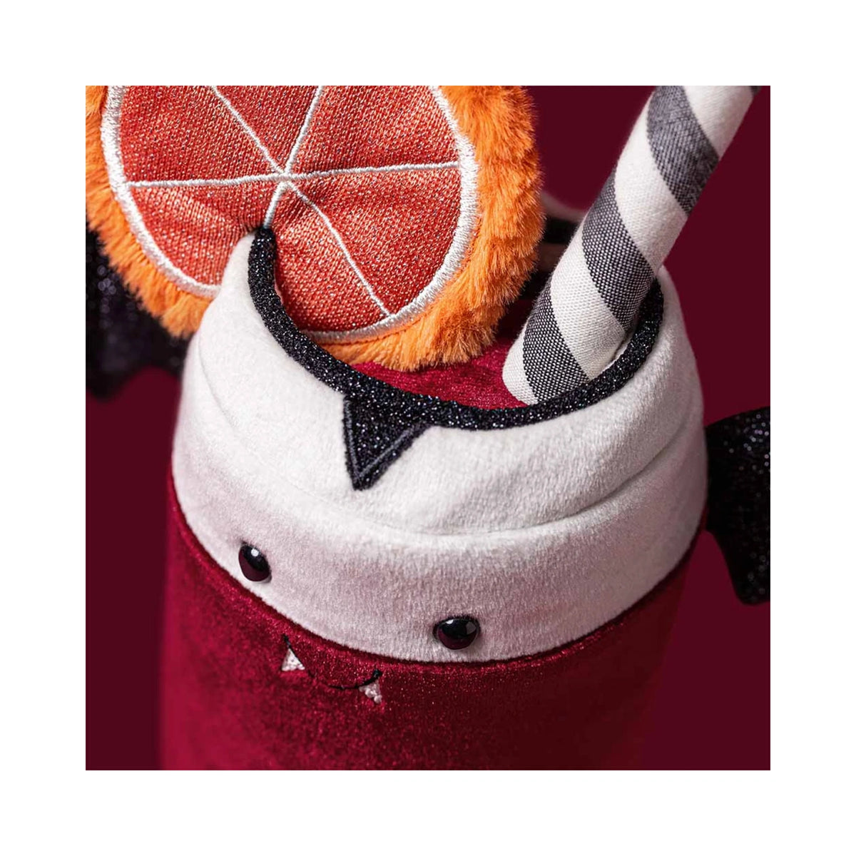 Close up detail of Jellycat Amuseables Vampop Drink showing orange plush fruit slice and striped straw.