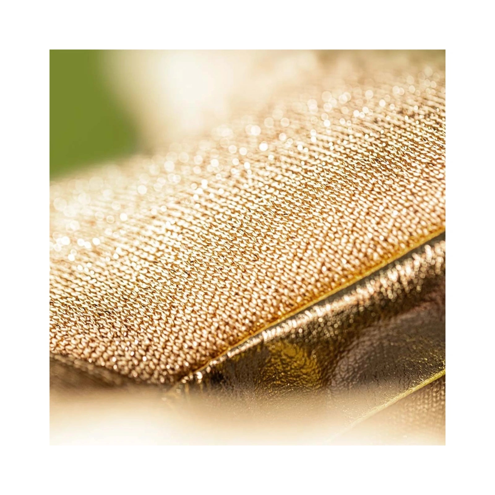 A close up detail of the Jellycat Amuseables Zapperty Lightning Bolt showcasing the sparkling gold metallic knit texture and shiny gold faux leather trim.