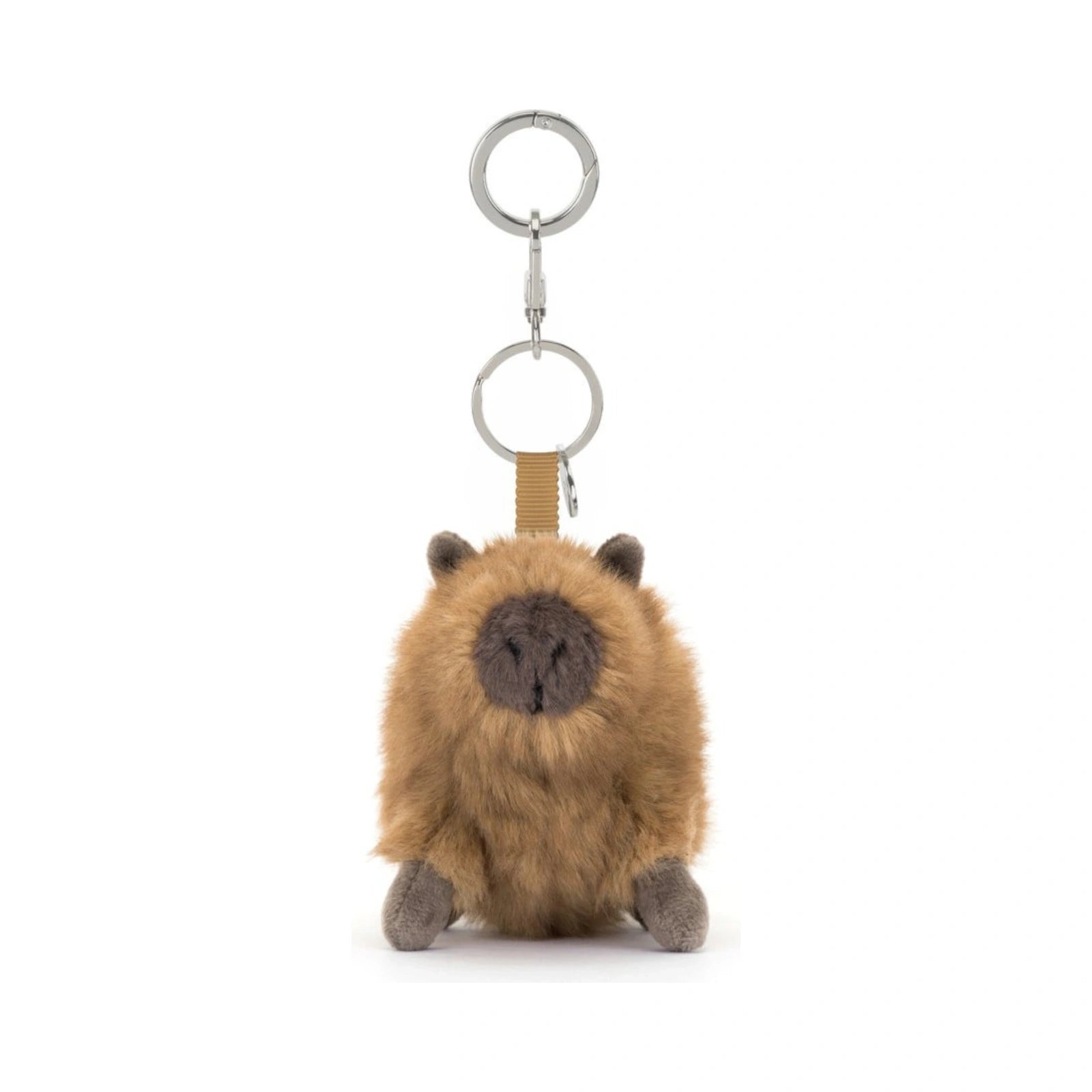 Jellycat Clyde Capybara Clip On Charm features a fluffy brown plush body with a dark grey face and paws attached to a tan fabric strap and silver metal keyring.
