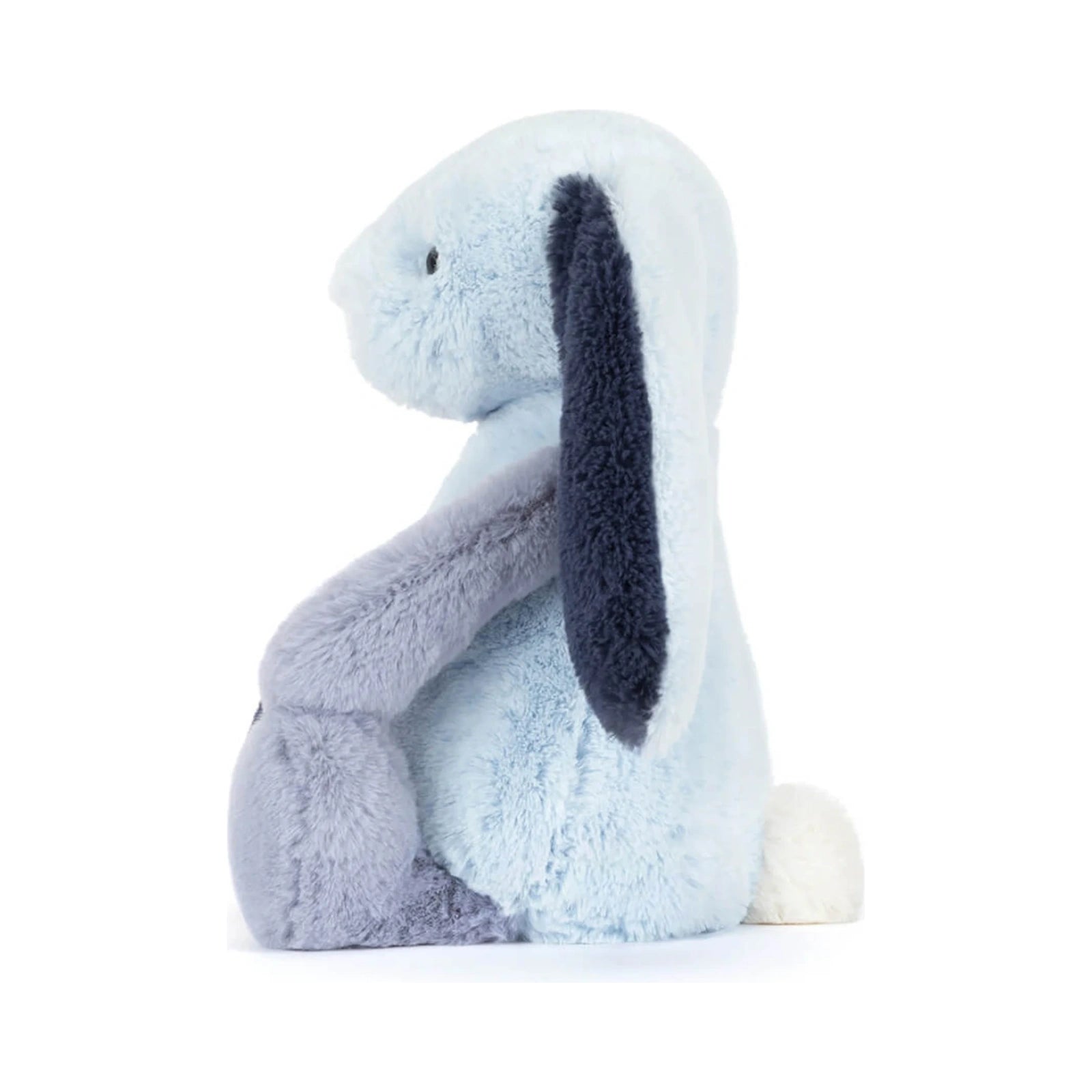 The Jellycat Puddlesea Bunny Original plush toy shown from the side, featuring soft light blue fur, a dark navy blue ear, a purple grey arm, and a fluffy white tail on a plain white background.
