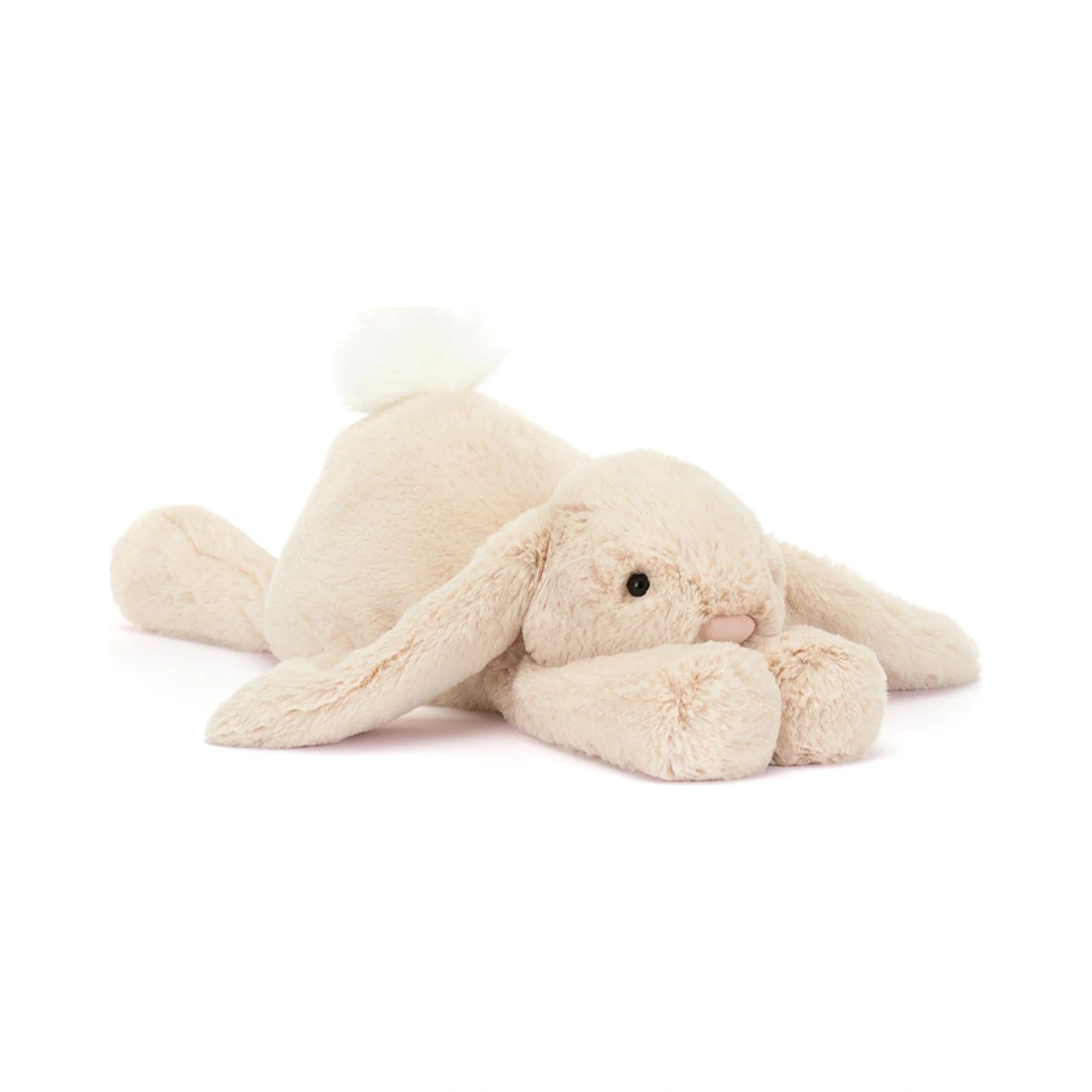 Jellycat Smudge Rabbit Medium plush toy in cream beige lying down with floppy ears, black bead eyes, and a fluffy white tail.