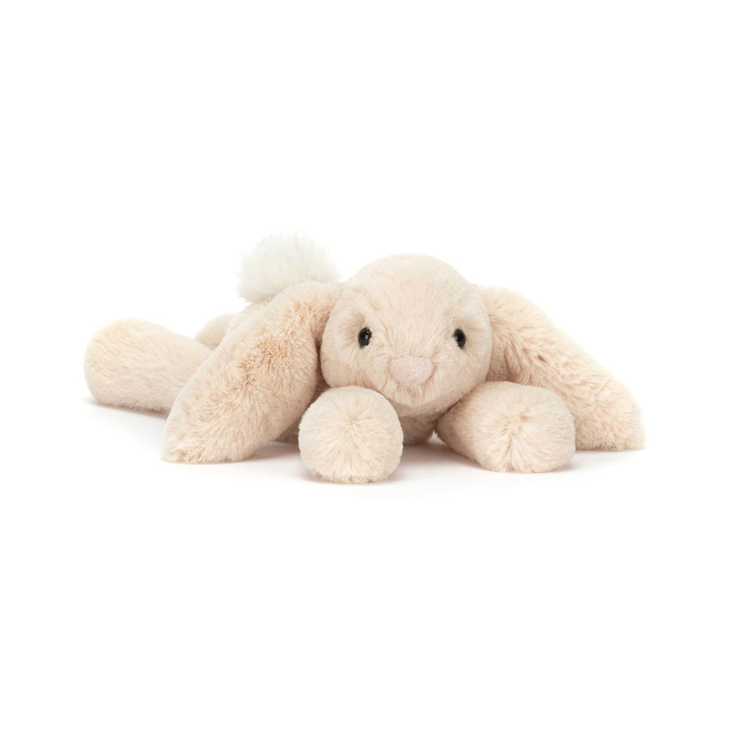 A pocket-sized, incredibly soft plush rabbit with creamy oatmeal-coloured fur, long floppy ears, and a sprawling, relaxed posture.