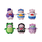 Six plush toys from the Pembe the Pink Cat mystery clip on plush blind bags collection, featuring light pink cat characters in unique outfits including a green frog costume, a black skeleton hoodie with a red heart, a purple artist beret, a striped sailor shirt with a yellow fish, a school uniform, and a purple polka dot outfit.