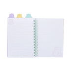 An open Pembe the Pink Cat PEMBE PROJECT BOOK displaying lined pages with lavender cat illustrations in the corners, bound by a light green spiral wire and topped with pastel purple, yellow, and blue cat shaped divider tabs.