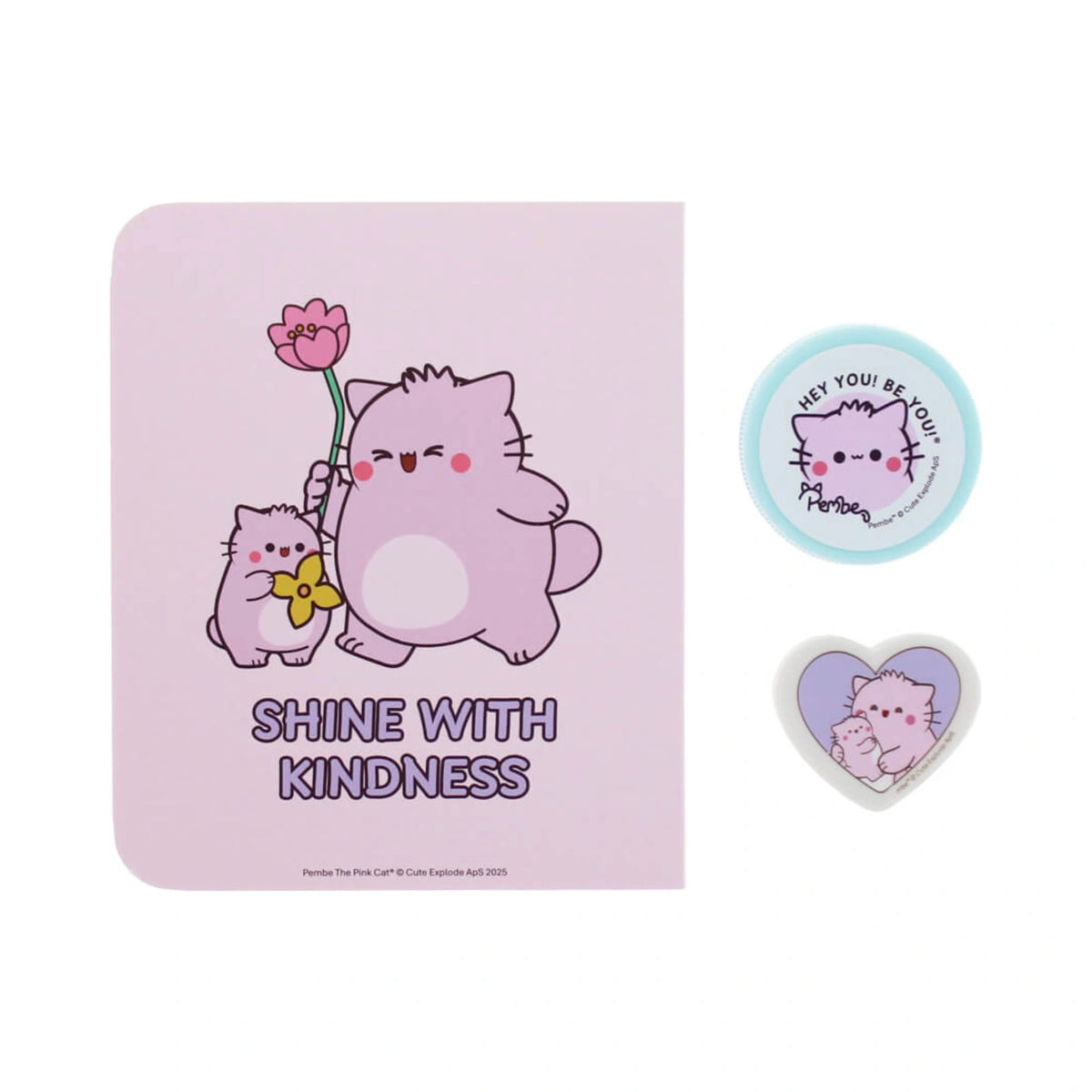 Pembe the Pink Cat stationery set featuring a lavender notebook with cute cartoon cats holding flowers under the phrase Shine with Kindness, paired with a small circular blue badge and a heart shaped cat badge.